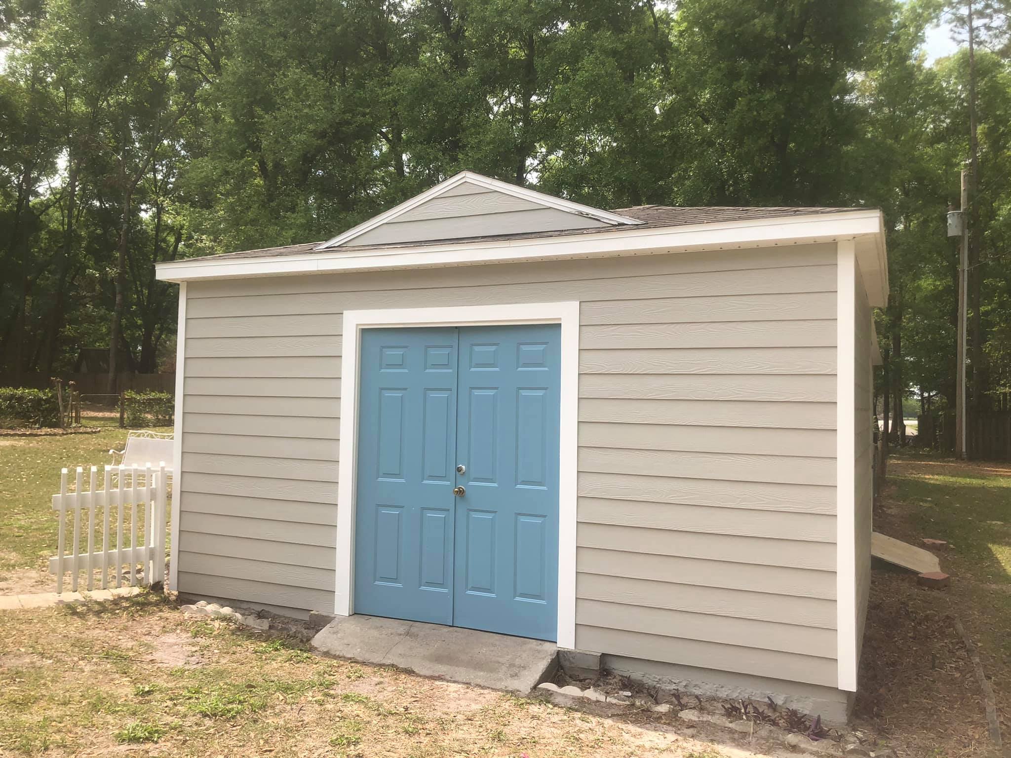 Same detached shed after fresh paint, trim, and door refinish