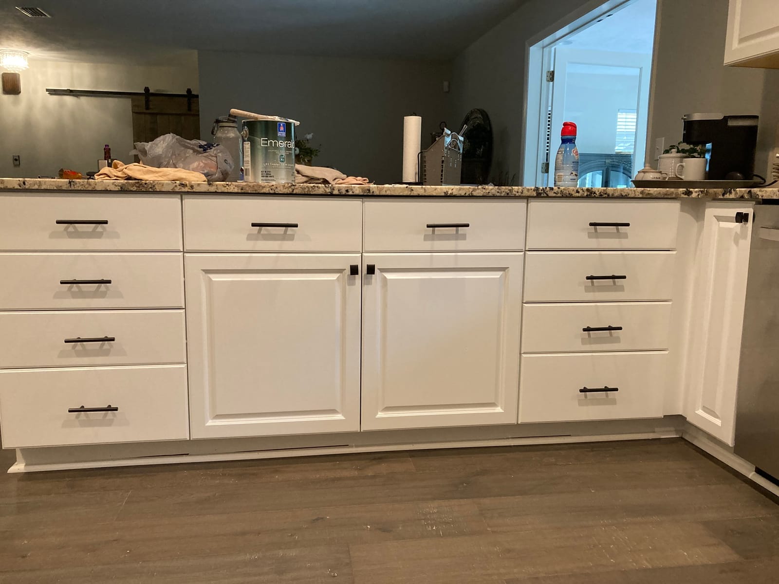Close-up of refinished white base cabinets with dark hardware