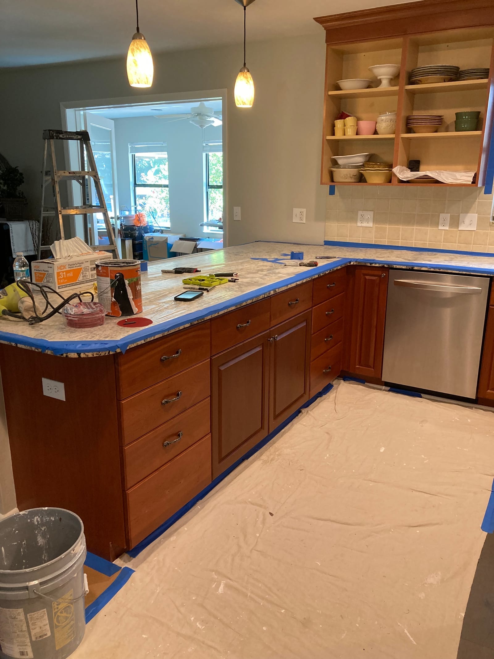 Kitchen cabinets mid-job, doors removed and frames masked off for paint