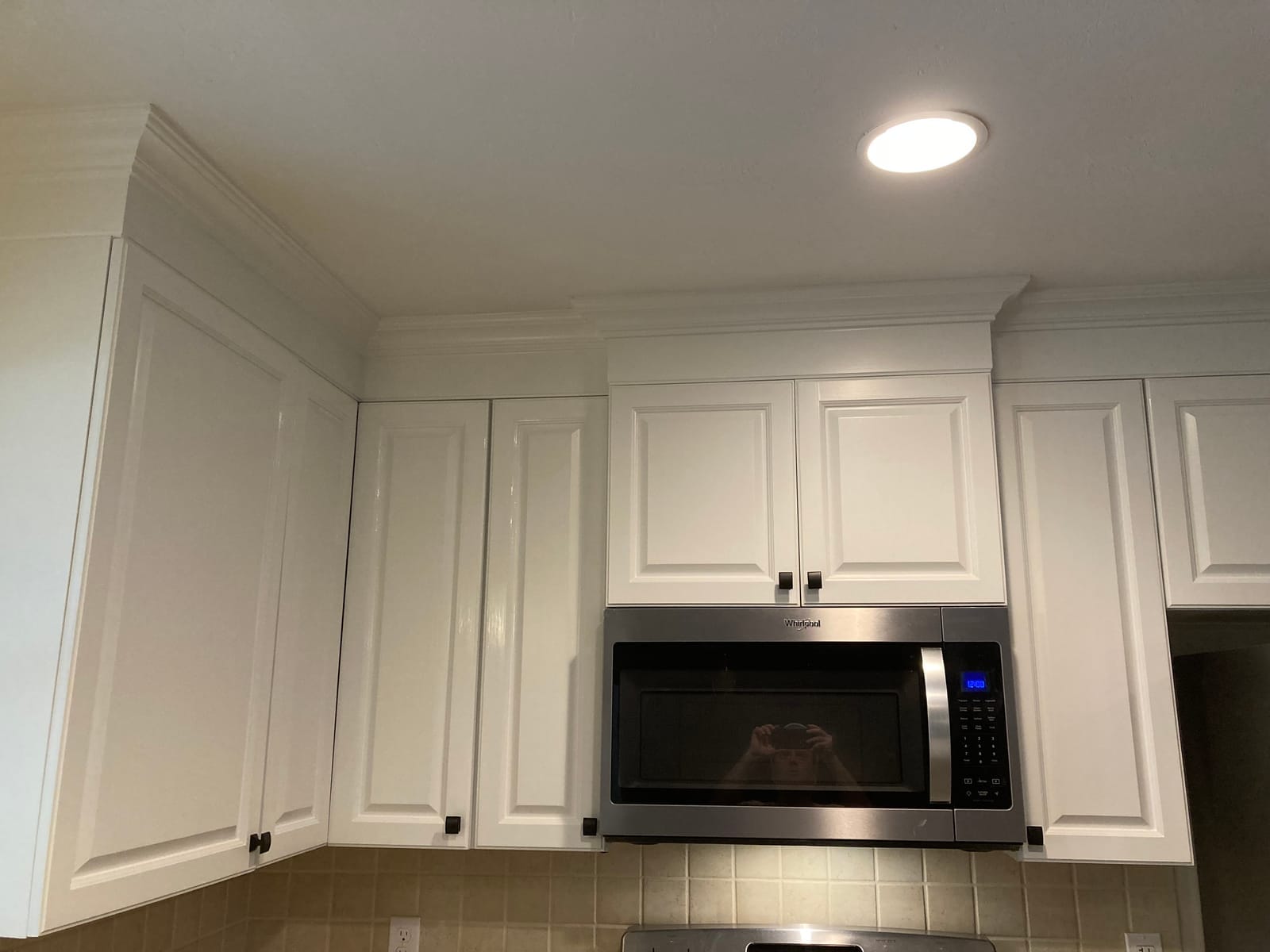 Refinished upper cabinets above microwave, white finish with crown molding