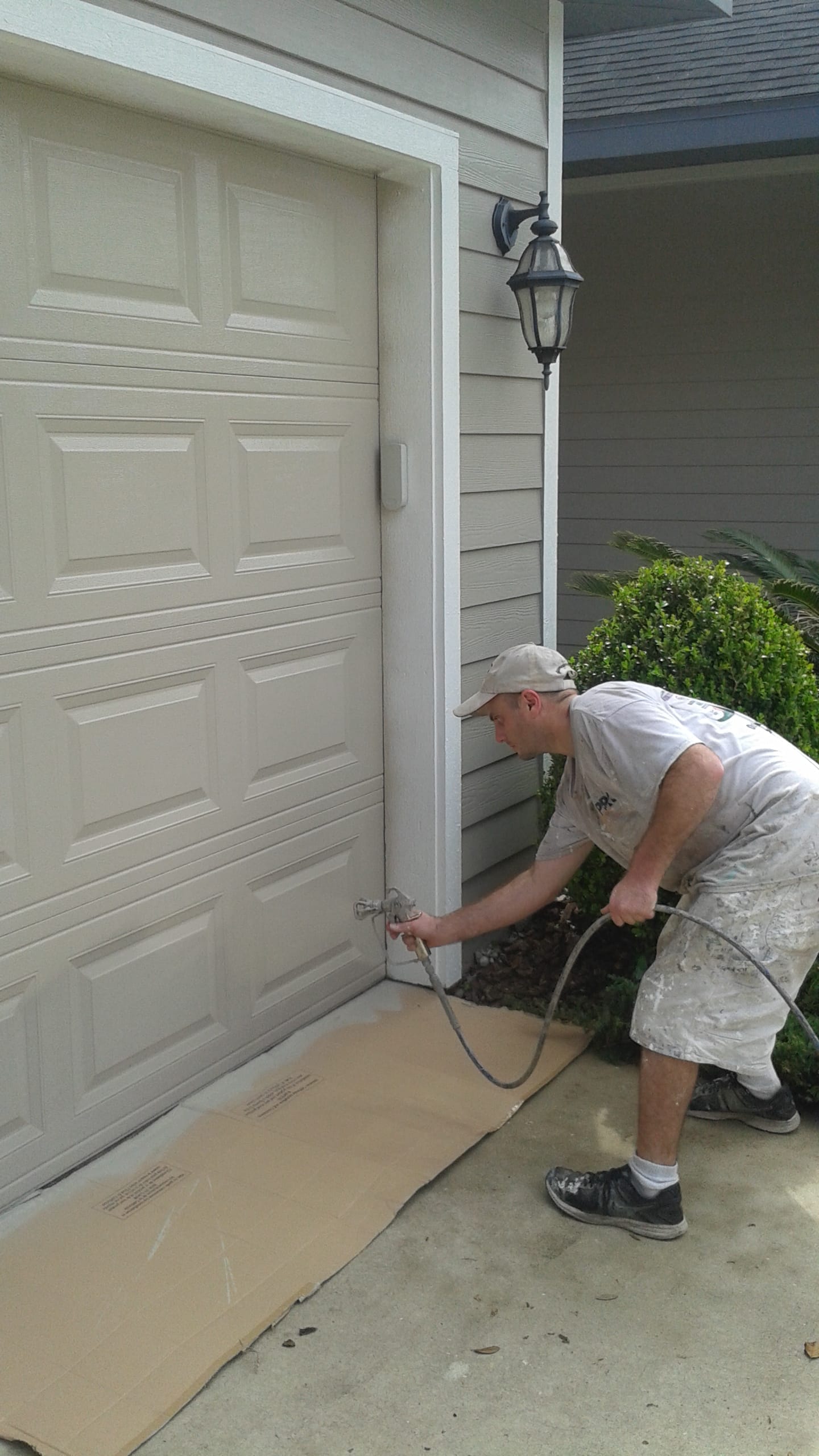 Christopher Combs spraying a garage door