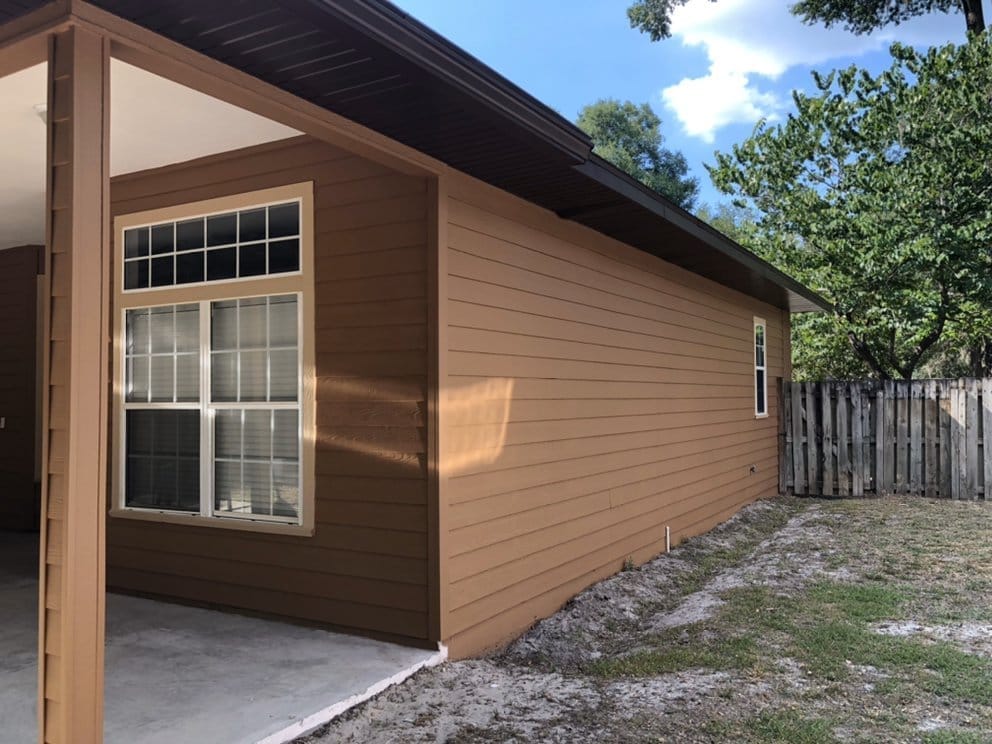 Siding home after, warm tan with dark trim