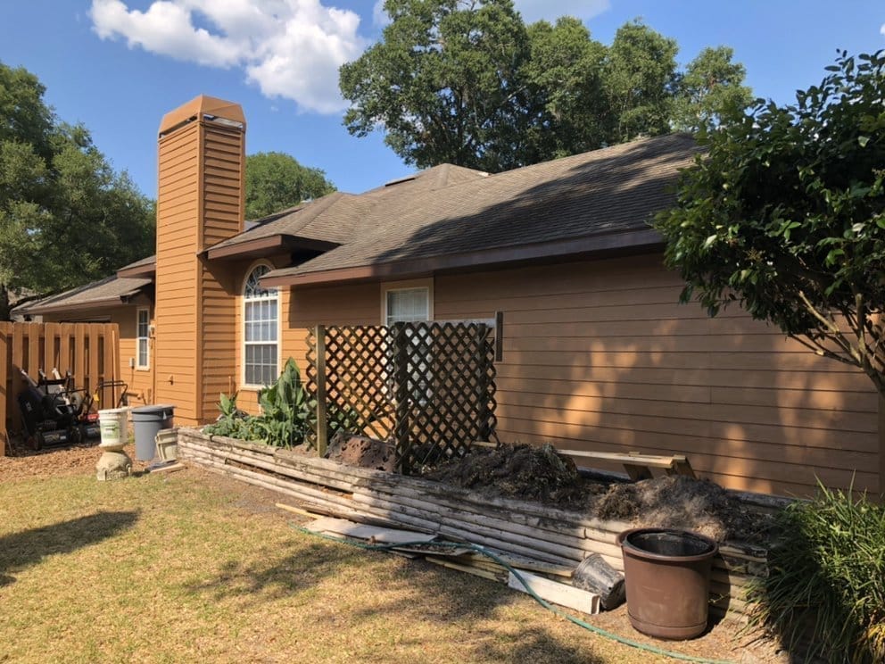 Side of home after, tan siding with dark gable