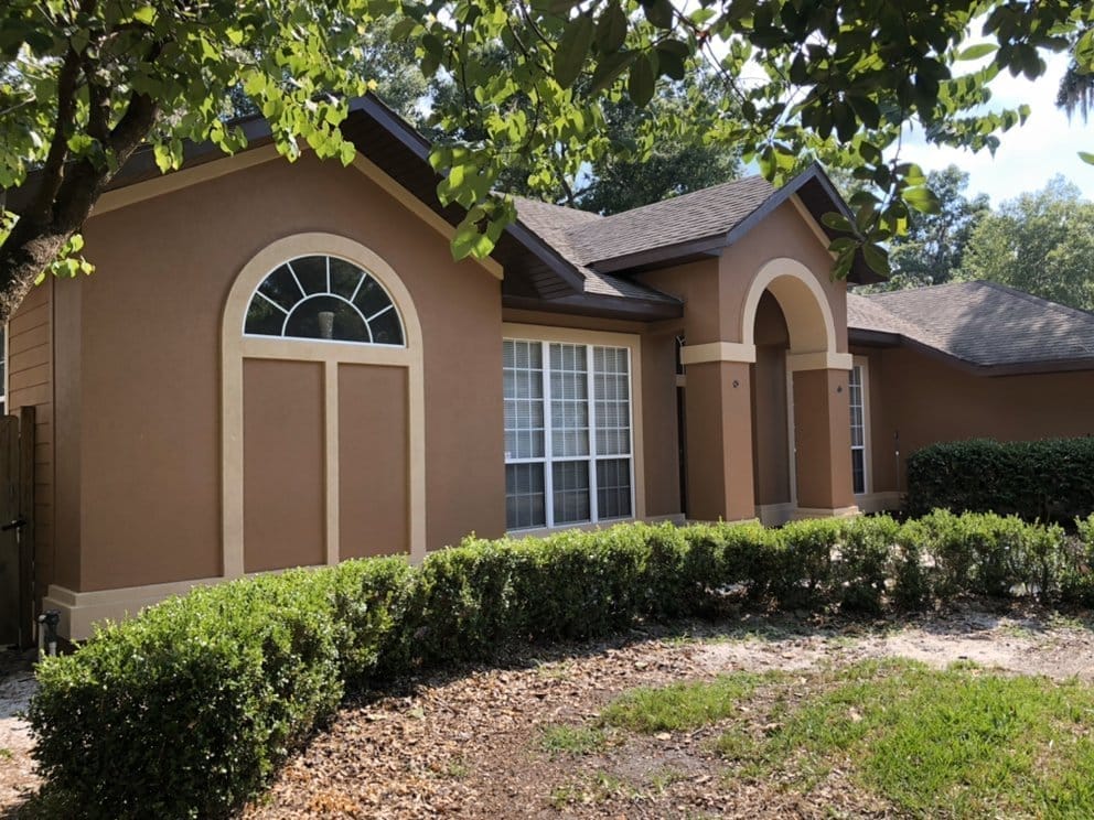 Stucco home after, warm two-tone repaint