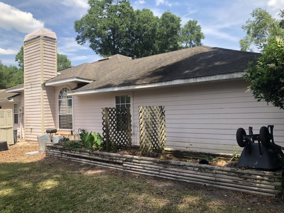 Side of home before repaint, lattice and weathered siding