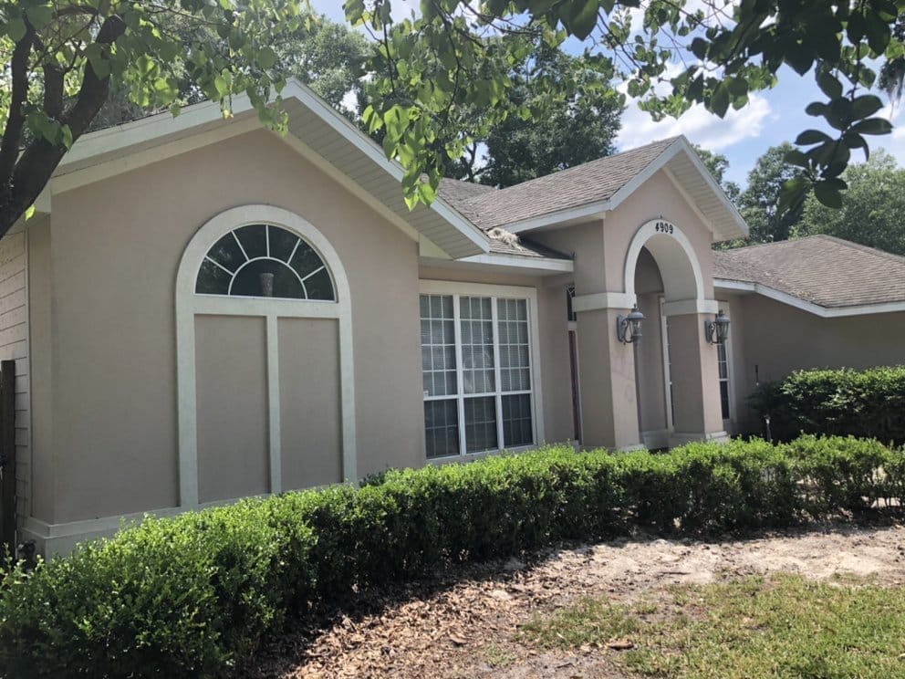 Stucco home exterior before repaint, faded cream