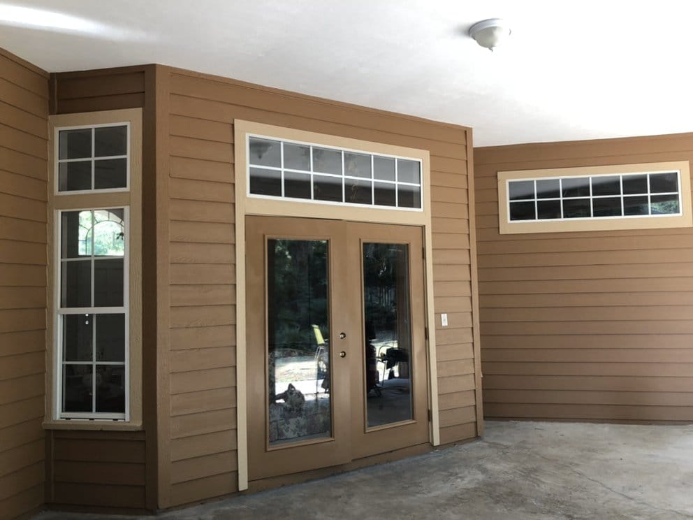 Back patio of repainted home, warm tan siding with French doors