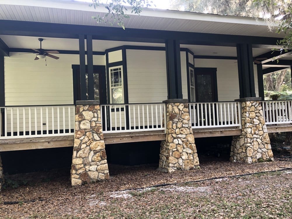 Side of porch home after, white siding with dark trim