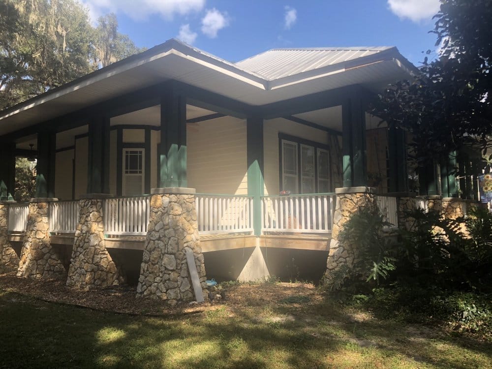 Porch home before repaint, cream walls with teal trim