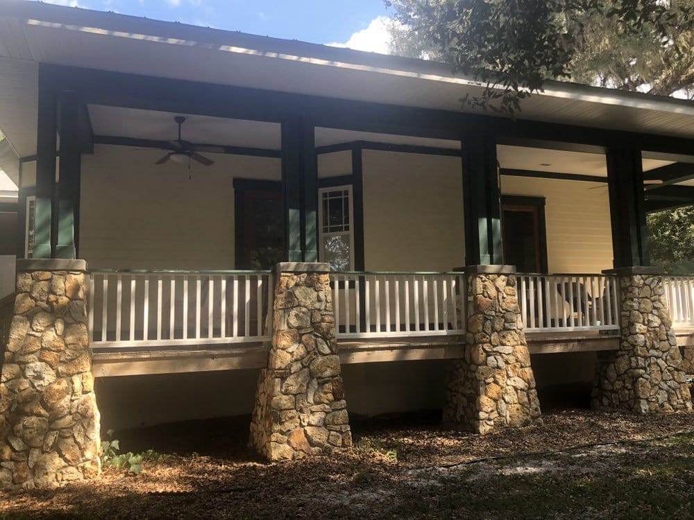 Side of porch home before, weathered cream paint