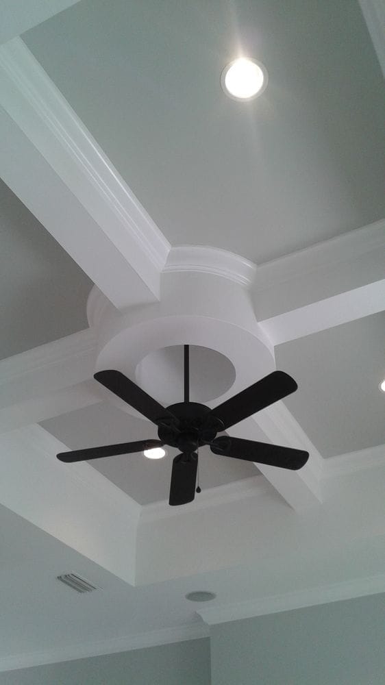 Coffered ceiling detail with crown molding and ceiling fan