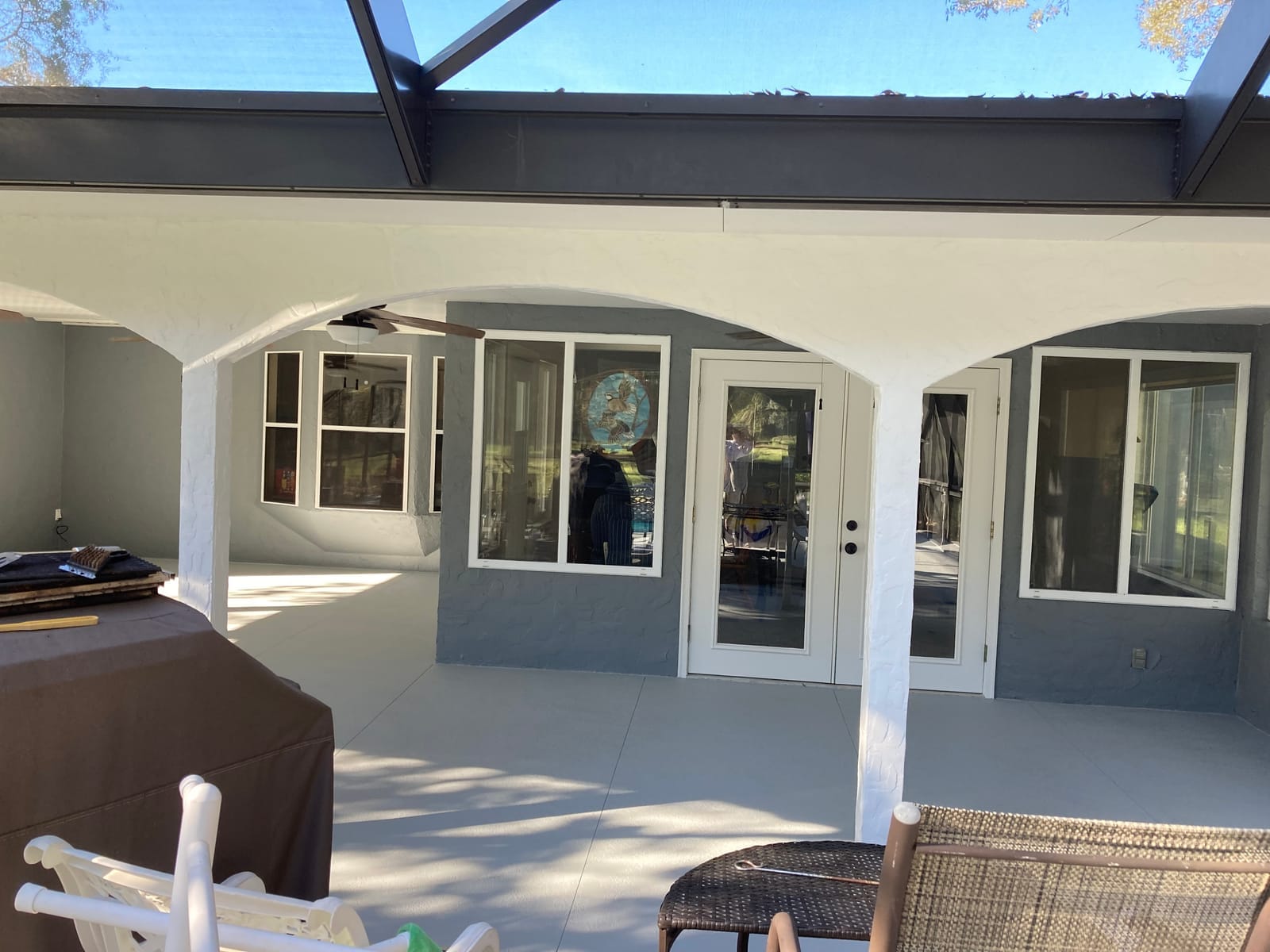 Lanai after repaint, soft gray walls with crisp white columns and arches