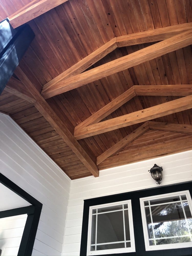 Porch ceiling beams stained back to warm amber